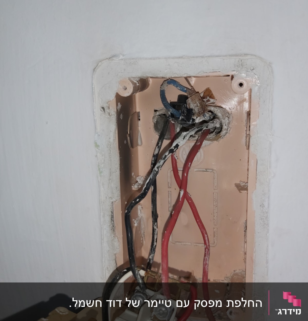 חוטי חשמל צבעוניים מחוברים לקופסת חיבורים בקיר